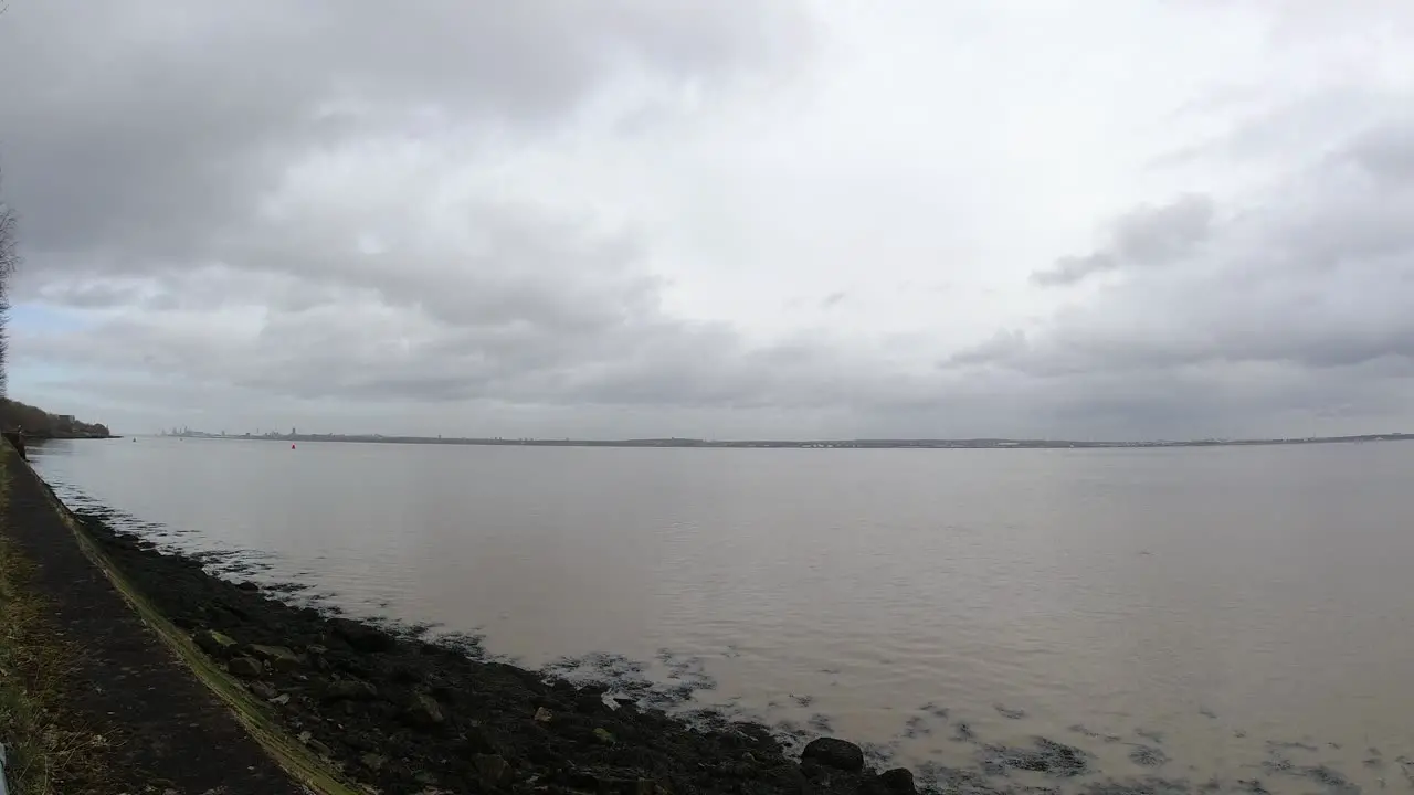 Overcast British river Mersey waterfront fast clouds timelapse over rippling coastal tide water