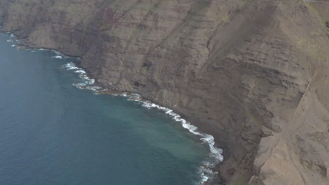 Panorama drone shot of waves bounce on rocks at the coast