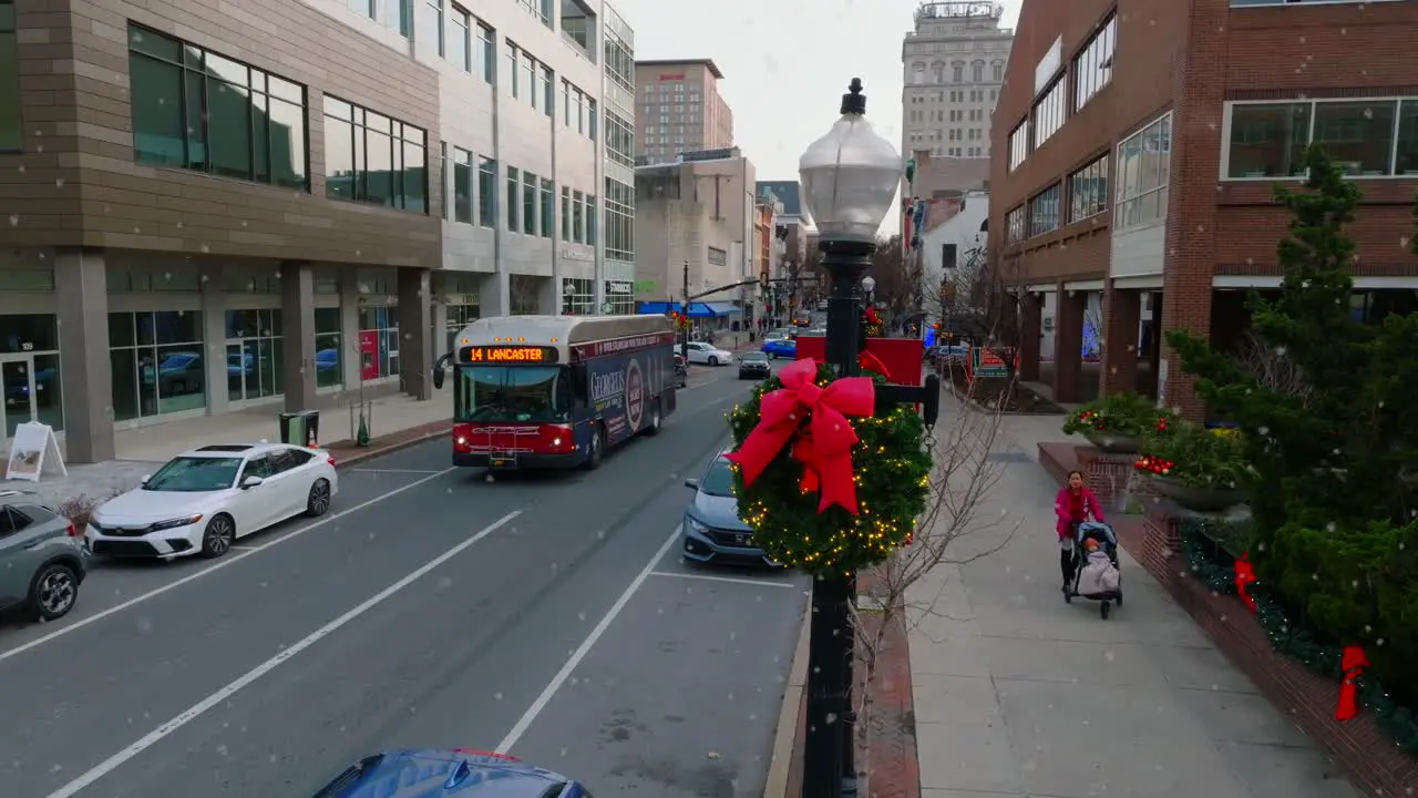 Aerial orbit reveal of city bus driving through downtown street in Lancaster Pennsylvania