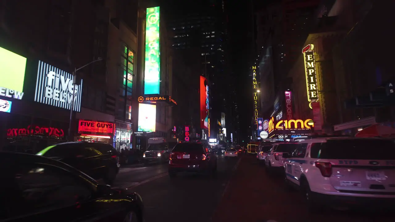 POV shot driving in middle of stores and illuminated ads night in New York USA