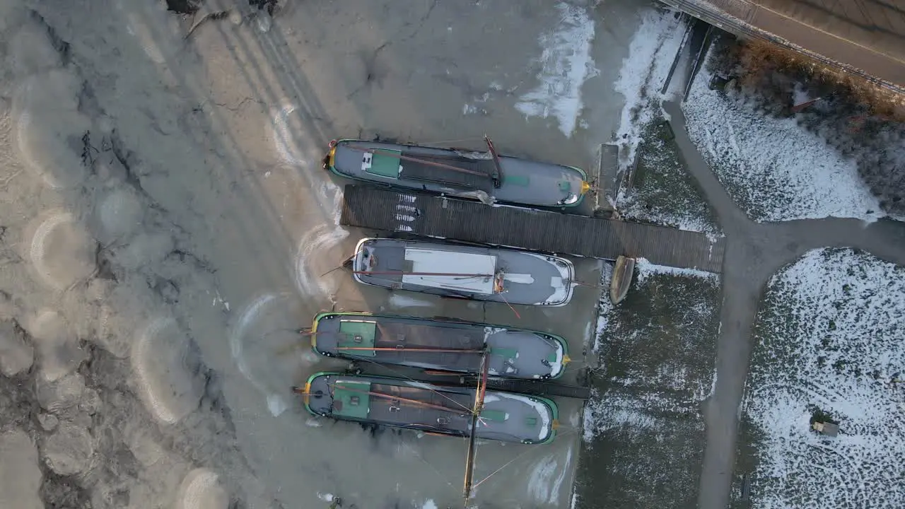 Traditional Dutch ships docked in harbor with frozen water in winter