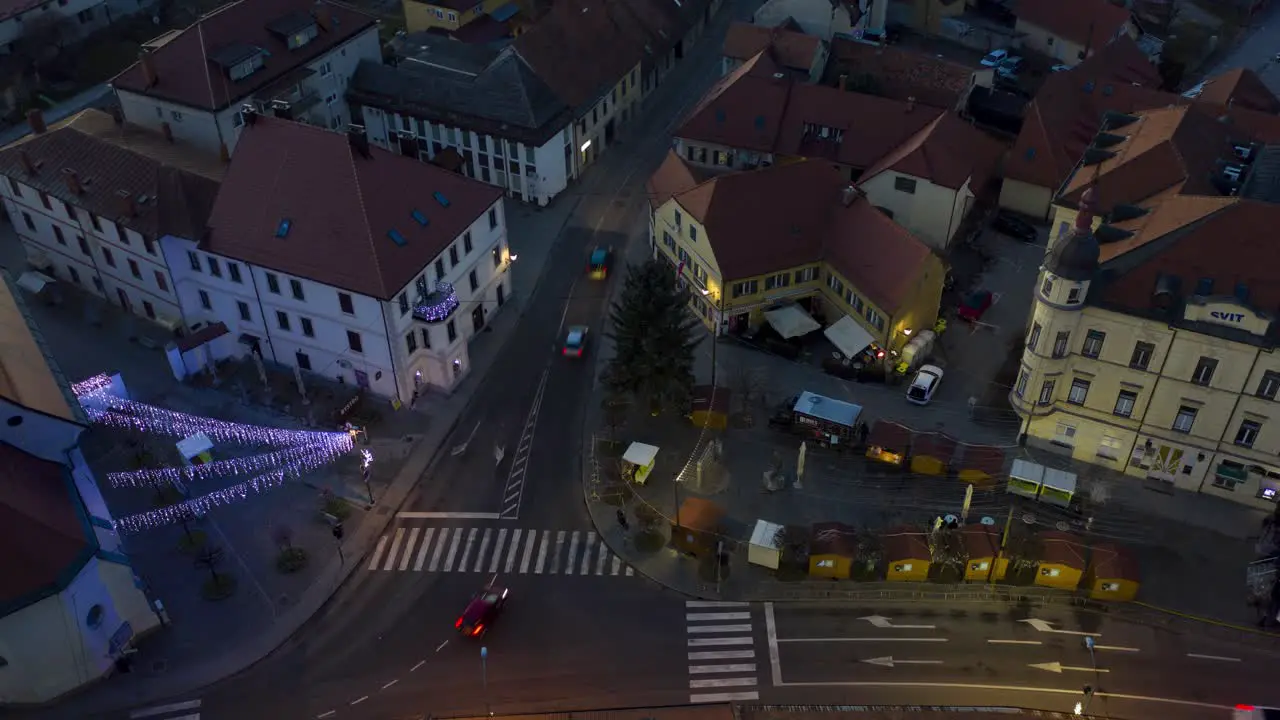 Christmas lights switch on in main square of small town aerial time-lapse of market with decoration slow zoom out