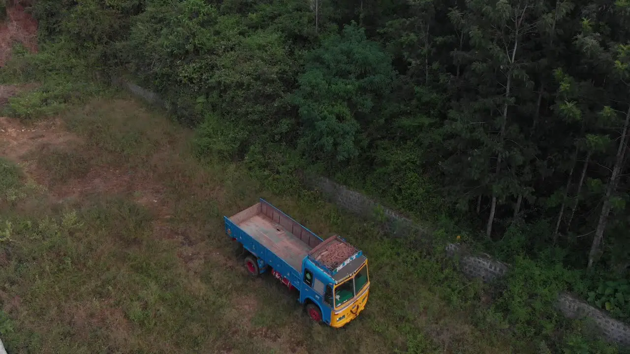 Aerial view over a colored truck parked near a rainforest jungle in a greenery natural environment wide shot conservation concept