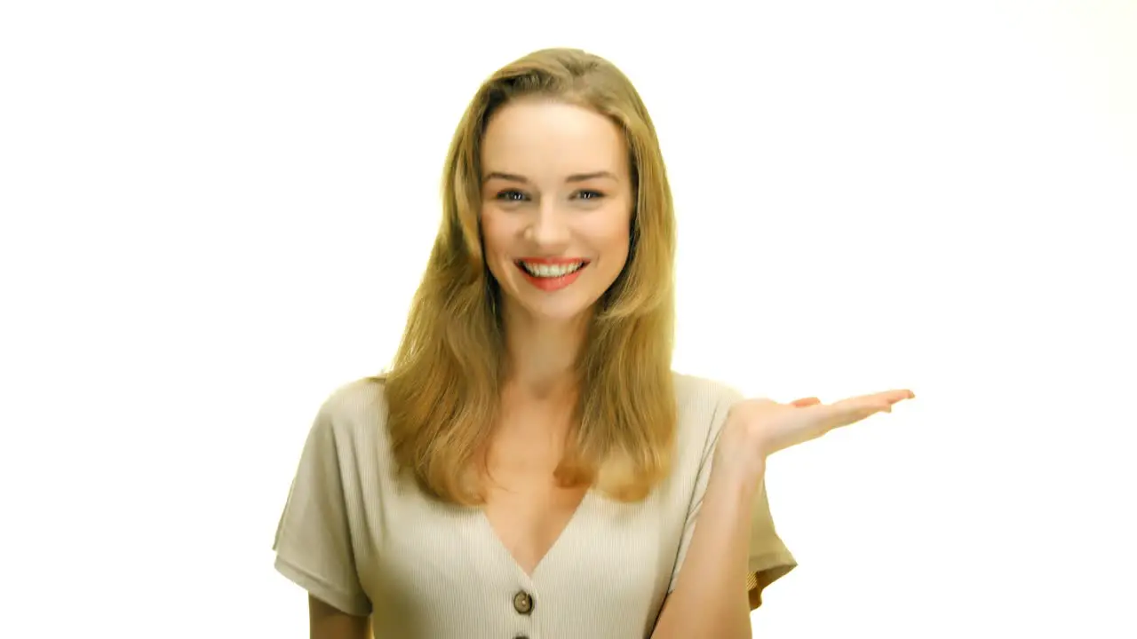 A close-up of a woman holding her hand up palm face up on a seamless white studio background