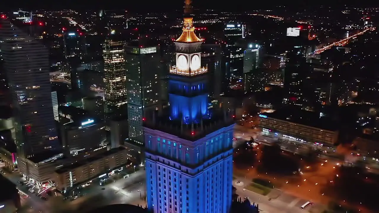 Aerial view of the illuminated Palace of Culture and Science in Warsaw Poland reverse tilt drone shot