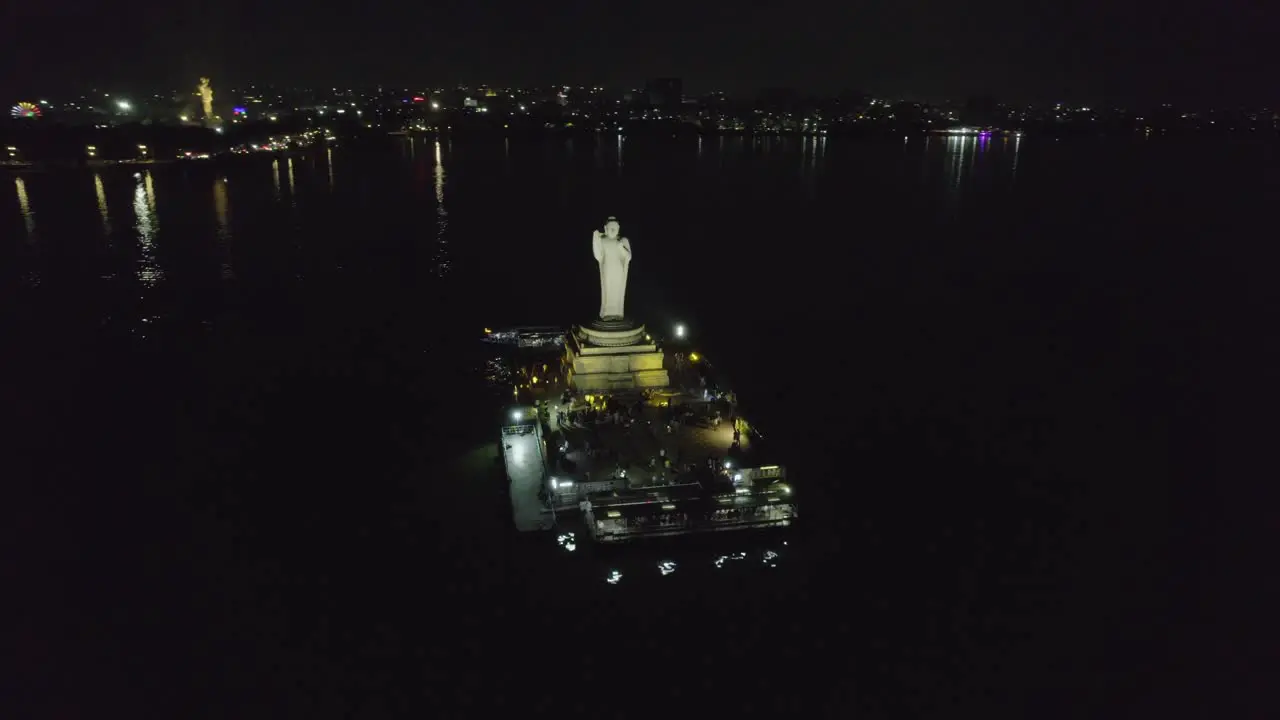 A cinematic aerial shot of Hussain Sagar Lake Hyderabad's most well-known landmark at night Indian monolith known as the Buddha Statue of Hyderabad