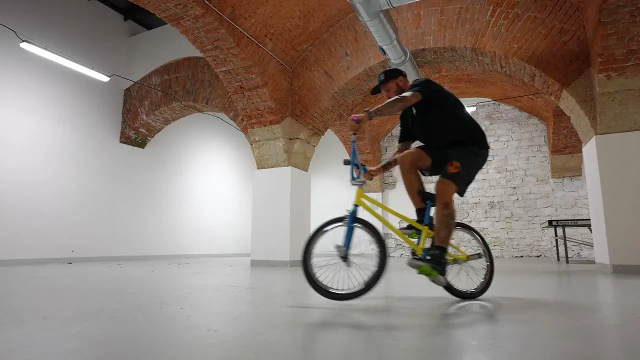 Biker riding his bike inside of a house doing tricks smooth shot