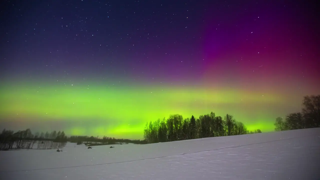 Green and purple norther lights glowing above the winter landscape aurora borealis time lapse