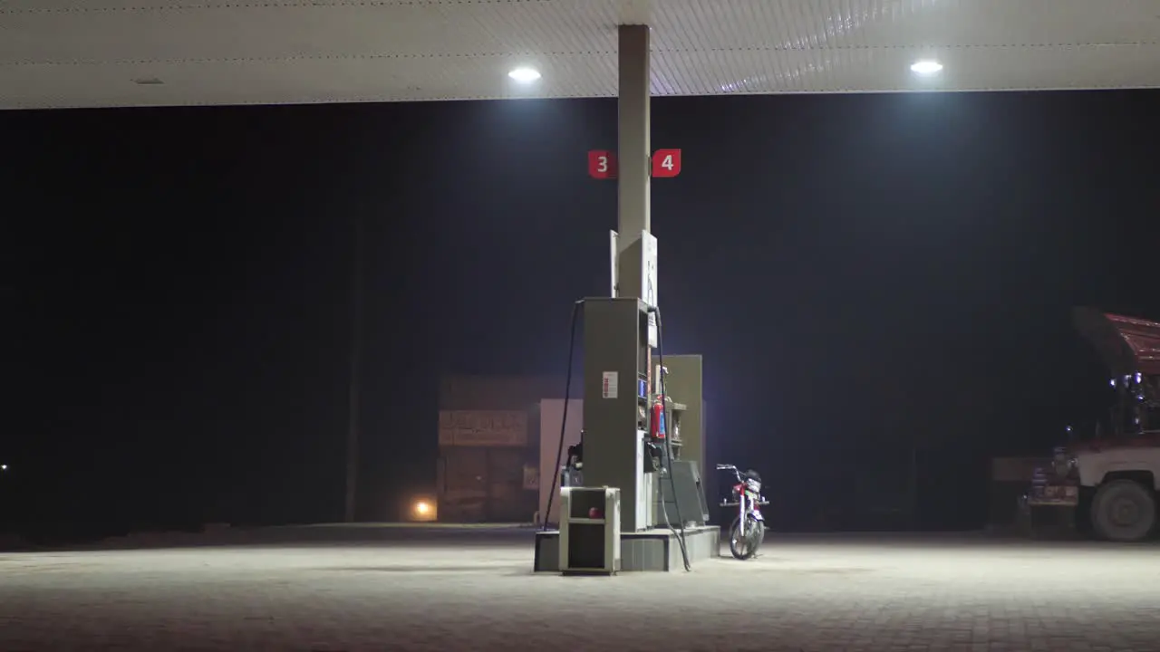 Shot of refuelling station beside a highway with bike parked at night time in Punjab Pakistan