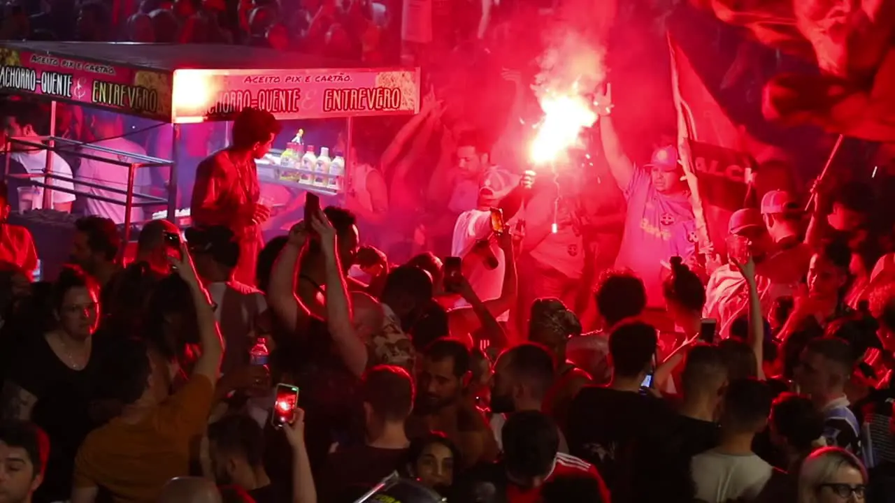 Lighting red flare and waving flags a crowd celebrates the election of Luiz Inácio Lula da Silva in the streets of Brazil