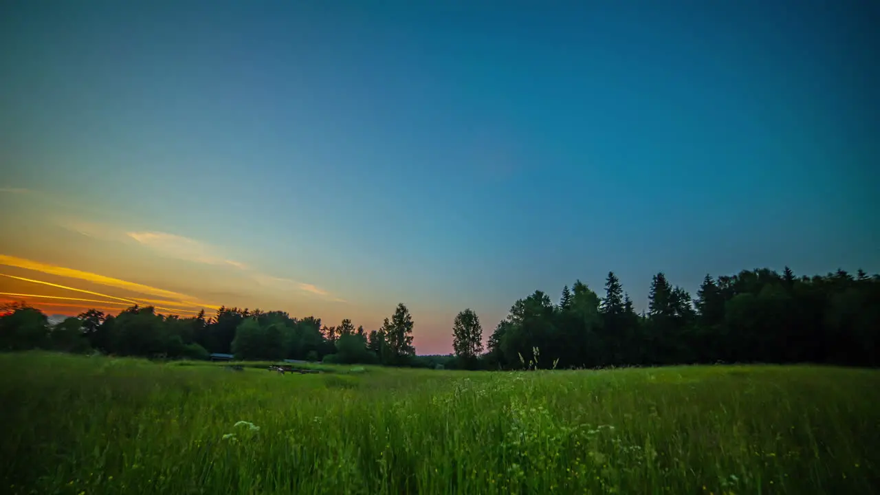 Golden sunset to nightfall time lapse over a countryside meadow and picturesque forest