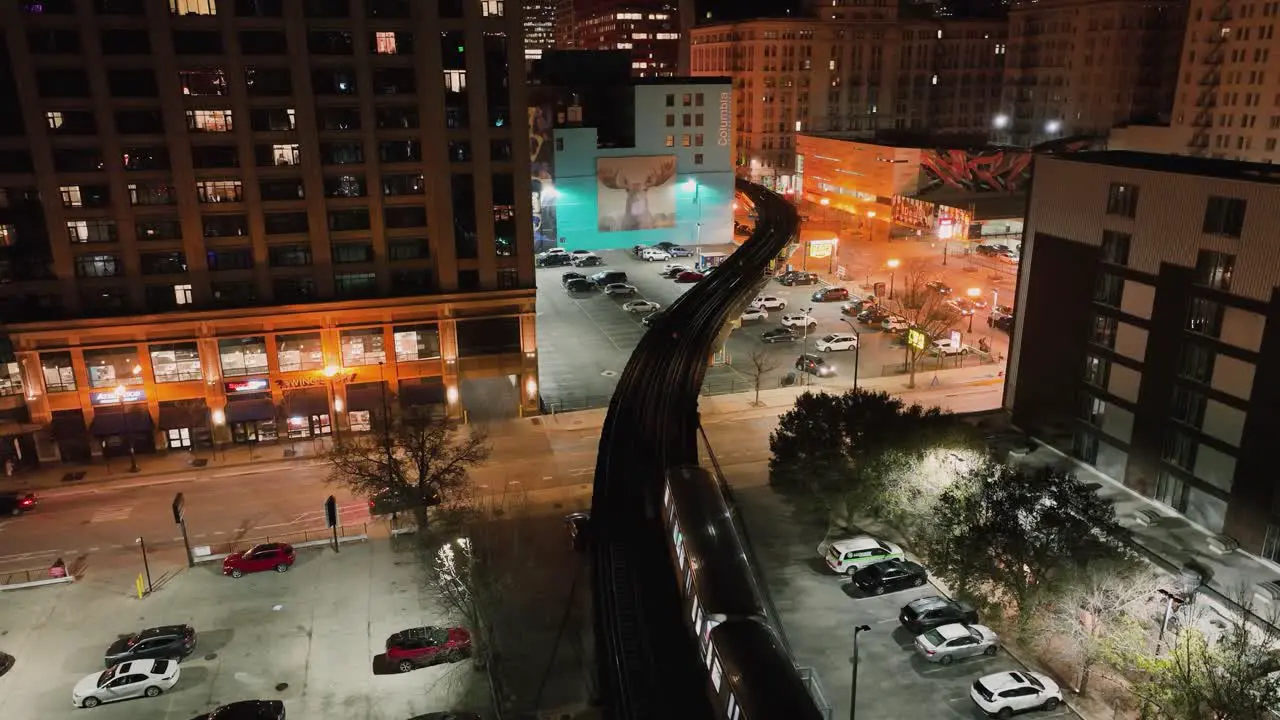 CTA train on a elevated rails in middle of buildings in illuminated South Loop Chicago USA Aerial view