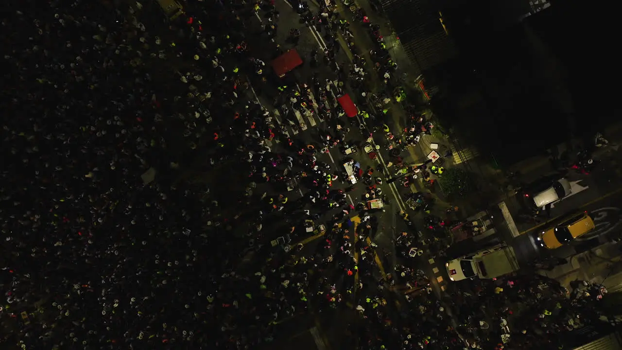 Aerial view of a ambulance on crowded night streets of Barranquilla at Carnaval Batalla de Flores in Colombia