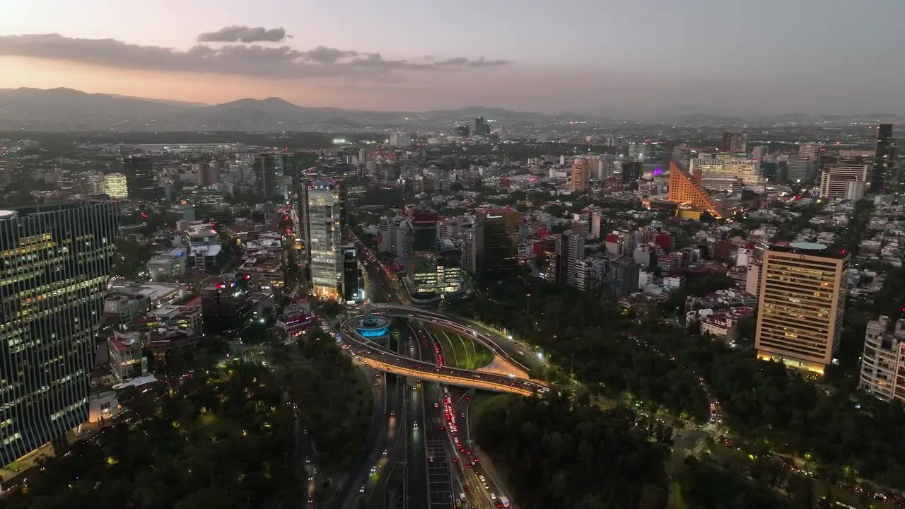 Aerial view around the Petroleos Fountain dusk on Reforma avenue in Mexico city circling drone shot