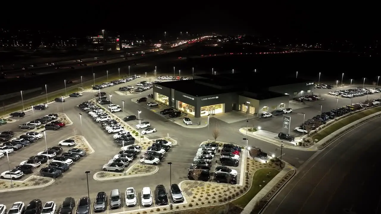 Jaguar and Land Rover luxury car dealership aerial nighttime establishing shot