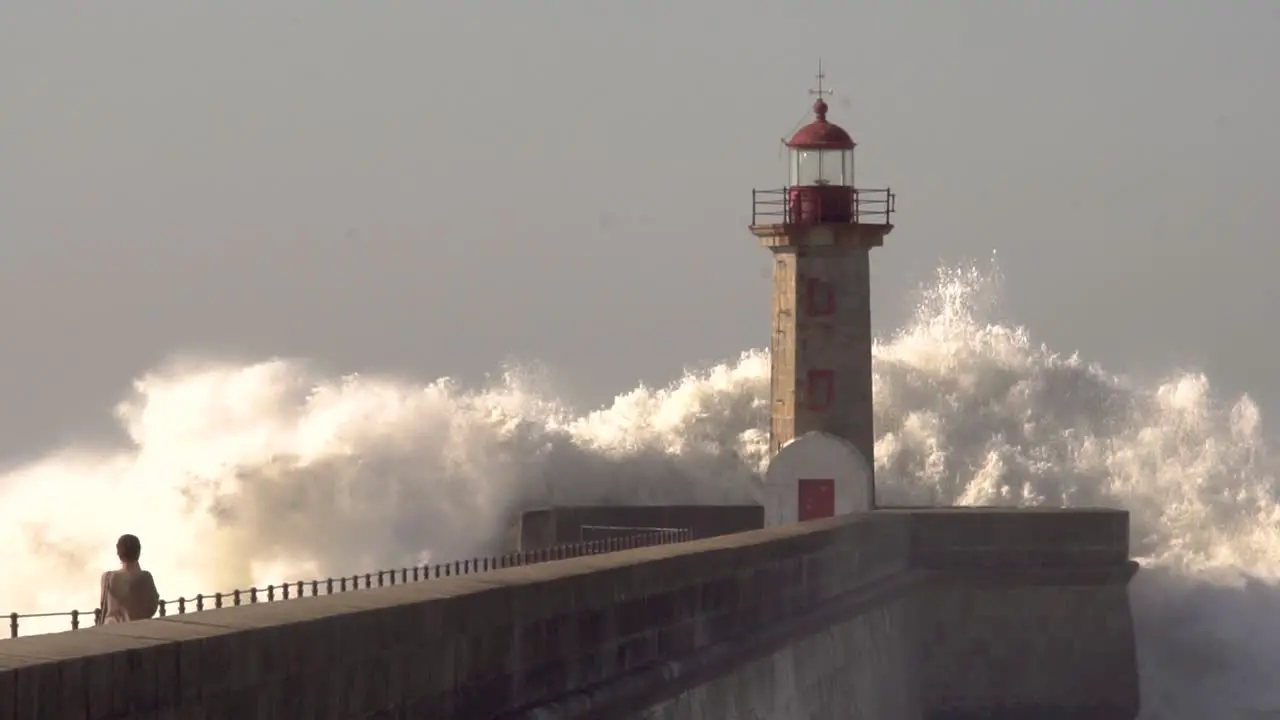 big waves crash over the lighthouse in the city of porto in portugal