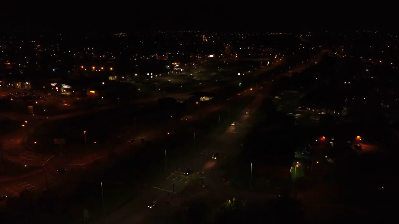 Midnight traffic headlights driving rural British town highway intersection aerial view