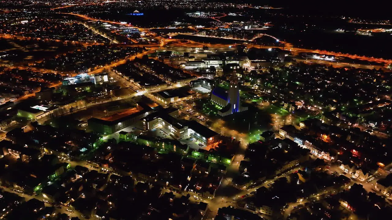 Drone shot around the Hallgrímskirkja church and the night lit cityscape of Reykjavik Iceland