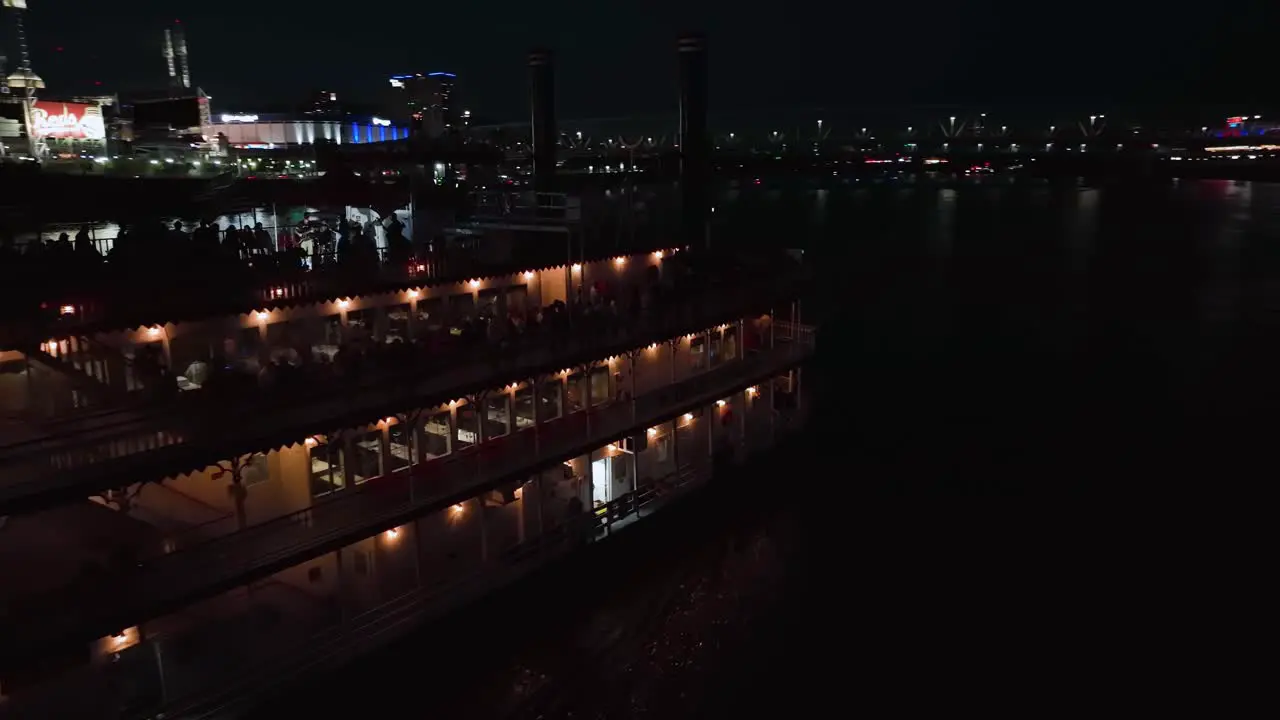 Aerial view around a steamboat driving on the Ohio river night in Cincinnati USA circling drone shot