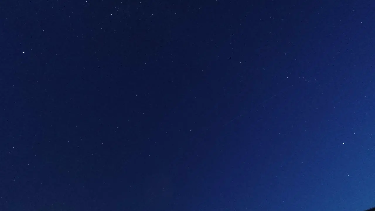 Time lapse looking up at clouds passing twinkling stars in the clear night sky