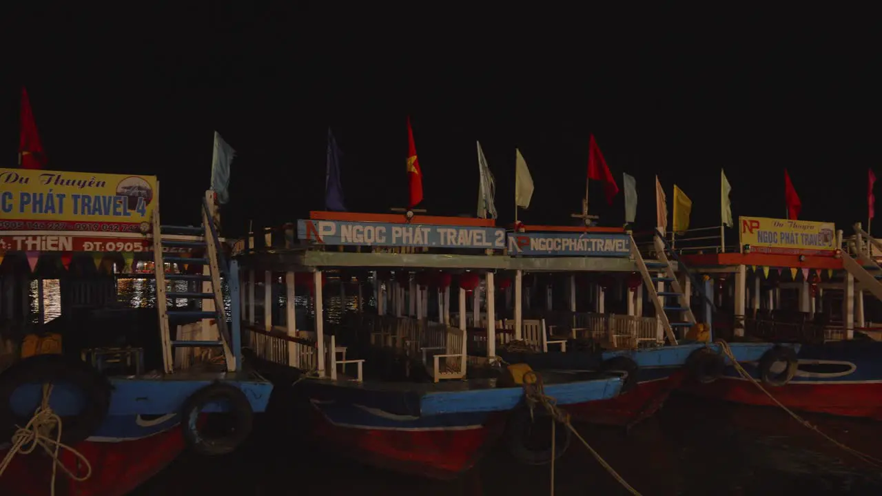 Night shot of boats moored at Thu Bon River waterfront in Hoi An Vietnam