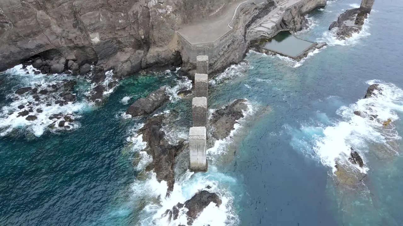 Top view of natural pools by the ocean with waves crashing on rocks in Pescante de Hermigua La Gomera