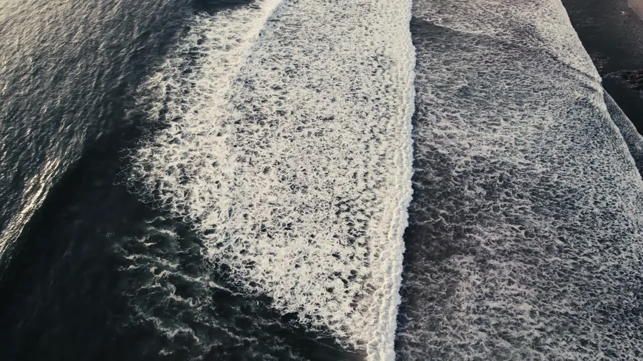 drone over a long and breaking wave during sunset in costa rica