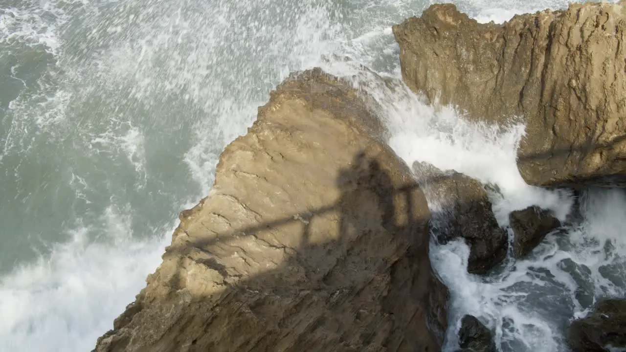 Slow Motion Wild Strong Winter Waves Crashing on Rocks with Shadow of a Couple