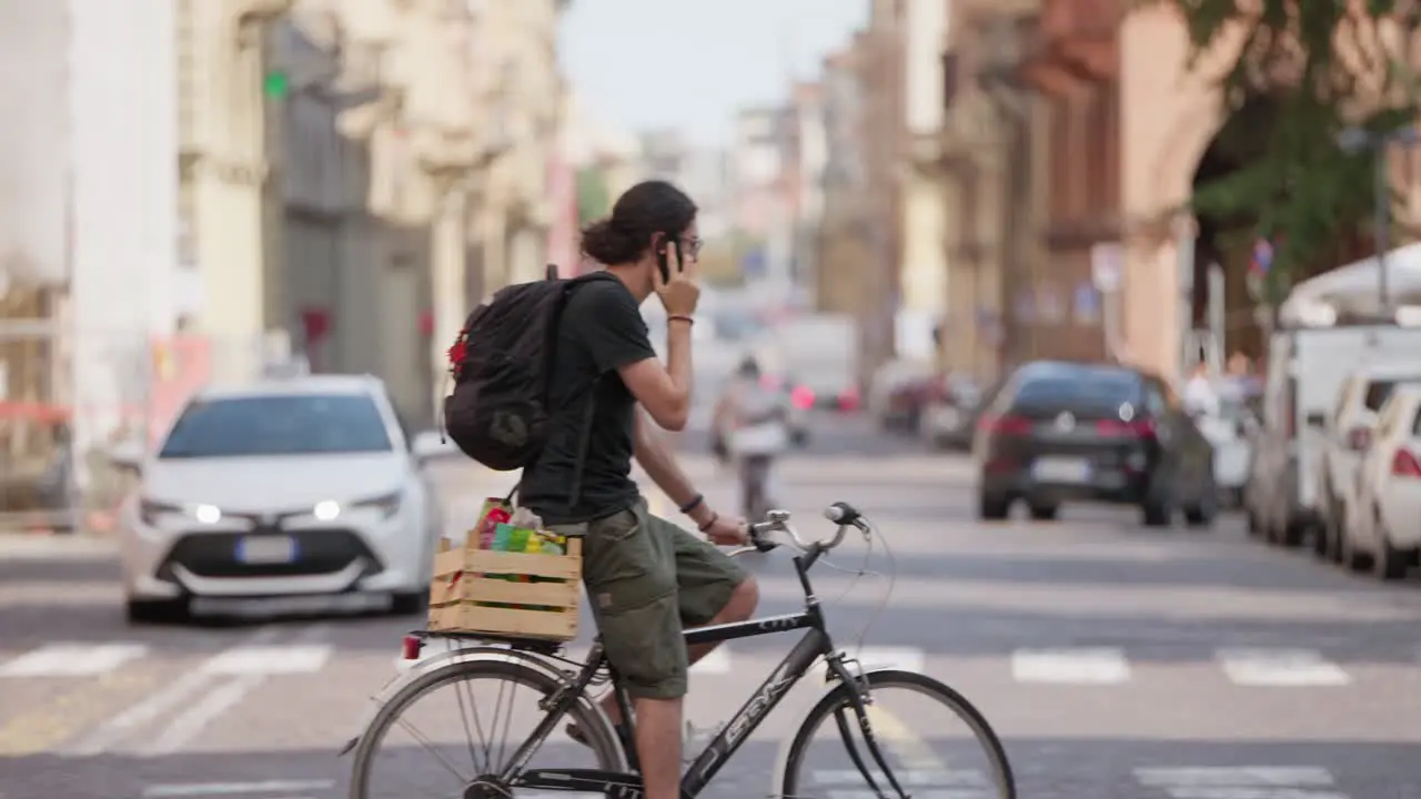 Static slow motion shot of city crossing with male cycklist passing in frame