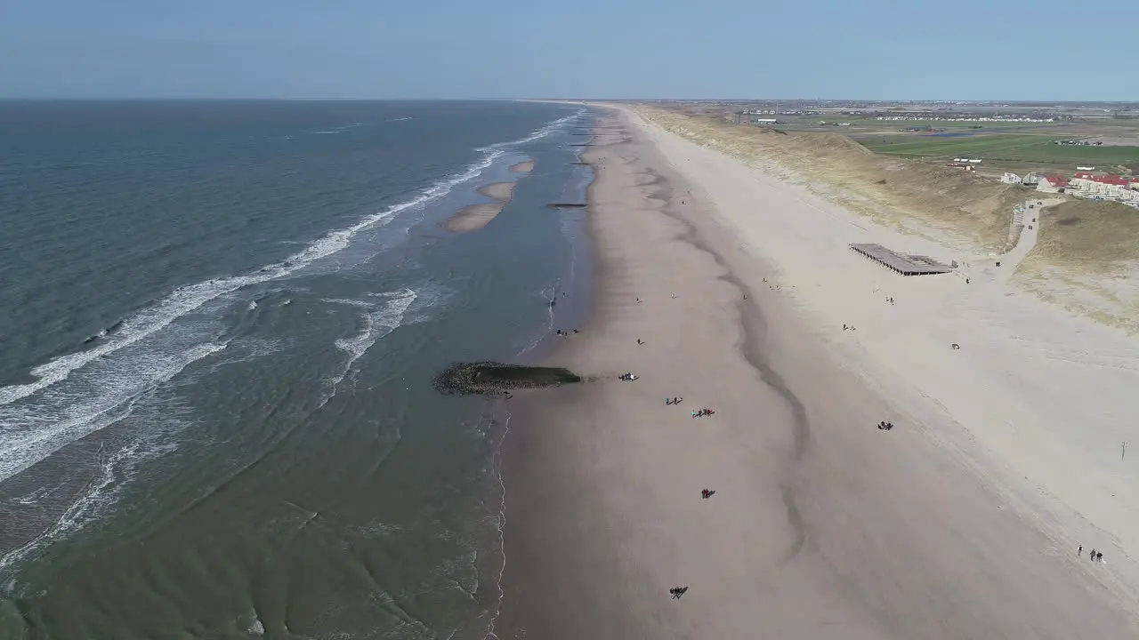 sunny day at the beach in the netherlands people walking on dunes