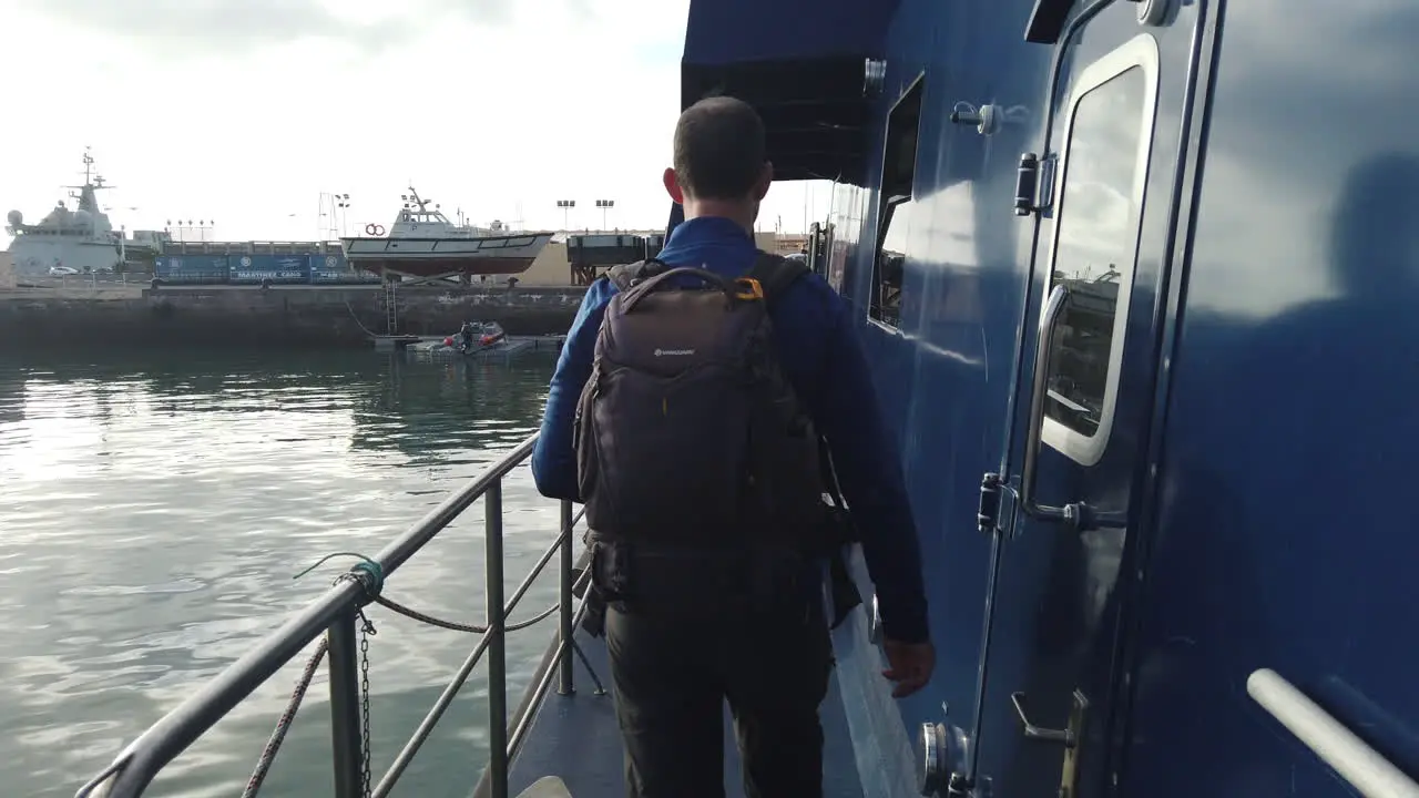 man with a backpack walks through the deck of the maritime patrol boat of the customs police