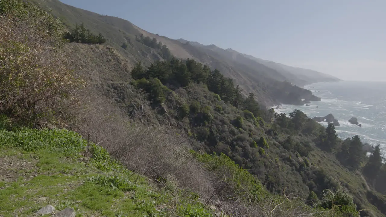 panning shot of mountain side to Pacific ocean at Big Sur California on a sunny summer day