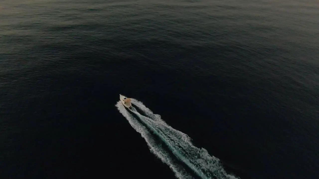 A boat sailing diagonally across the frame into the morning sunrise light