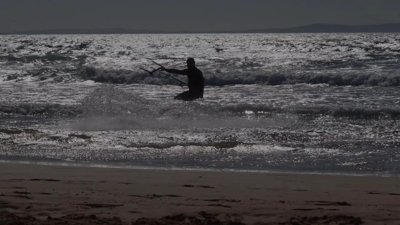 Kite Surfers and Dog in the Dark Ocean Waves during Sunset