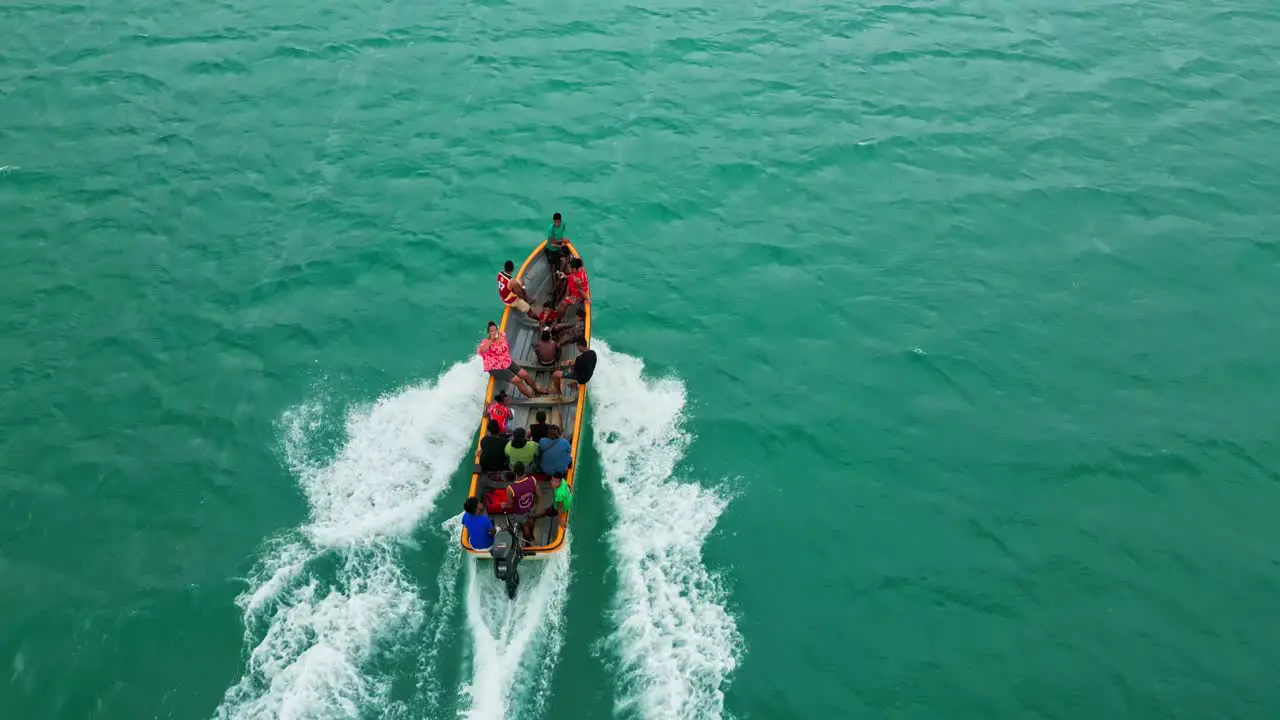 People with smiling faces enjoying a ride over calm waters in a dinghy