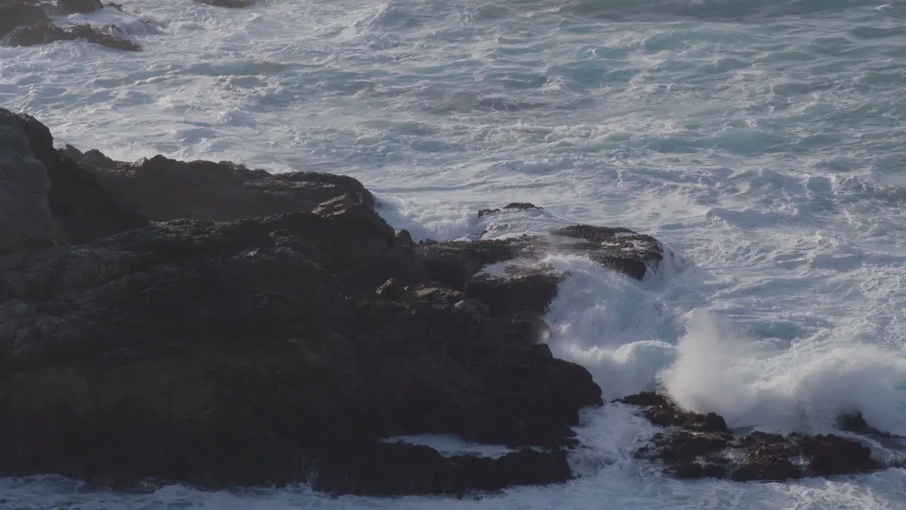 Stationary shot of angry waves crashing along the rocky shore of Big Sur Beach California