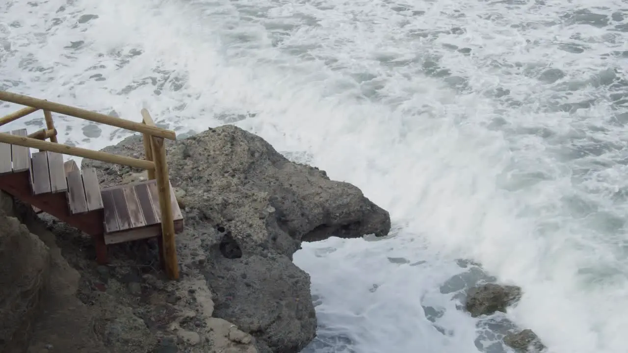 Slow Motion Strong Wild Sea Waves Crashing Into a Wooden Staircase and Rocks in Cyprus