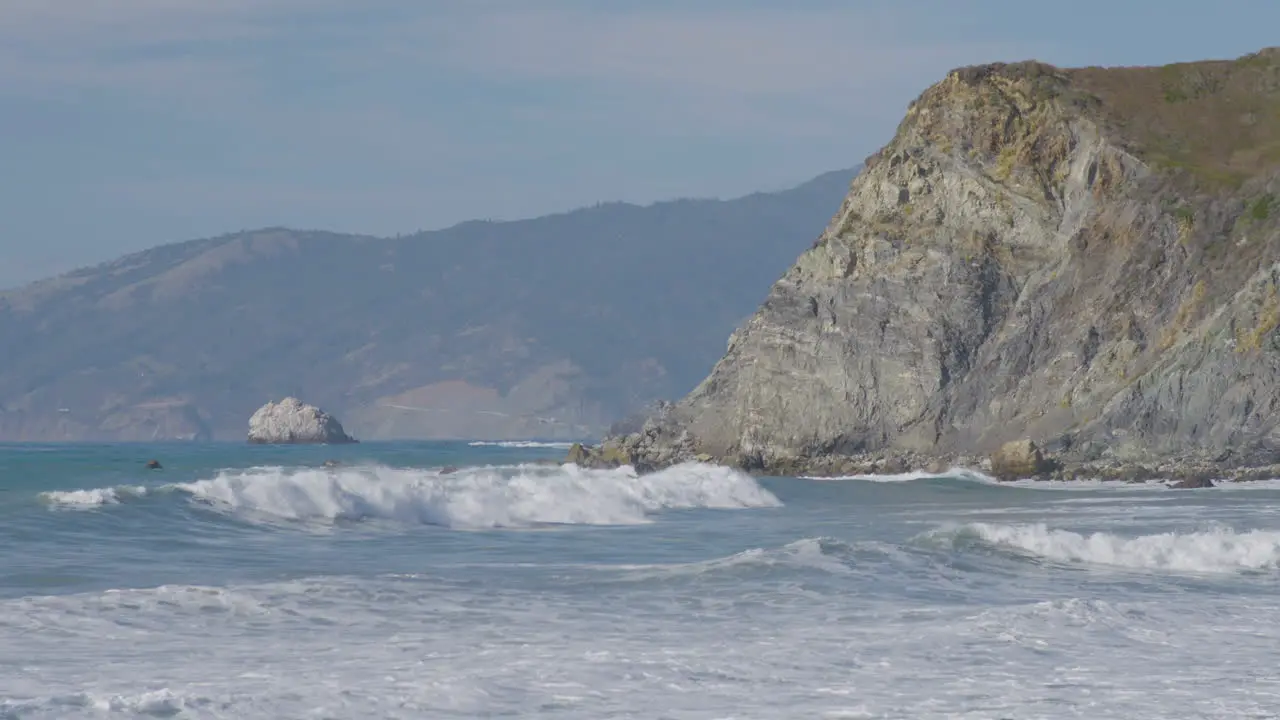 beach view of waves crashing along the cliff side of Big Sur California beach