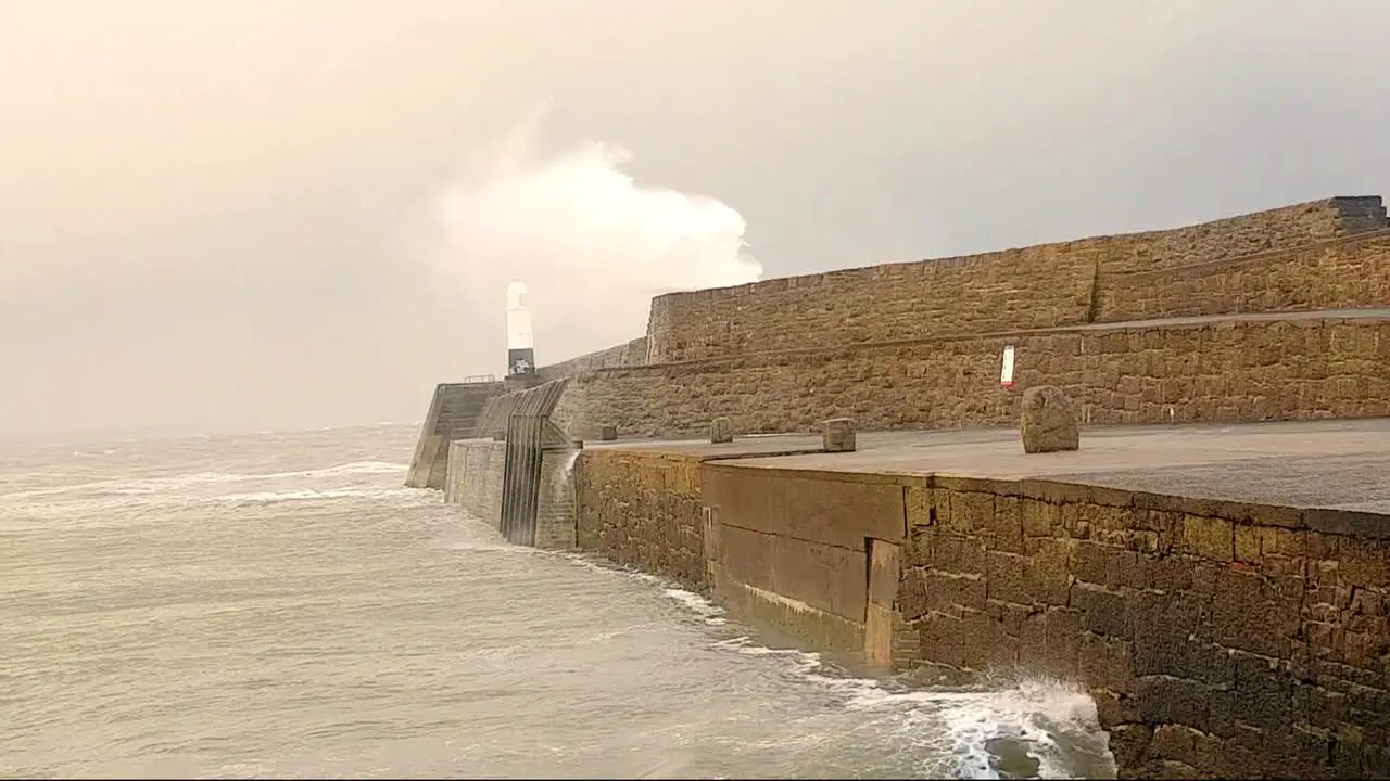 Waves crashing over sea wall during storm Atiyah