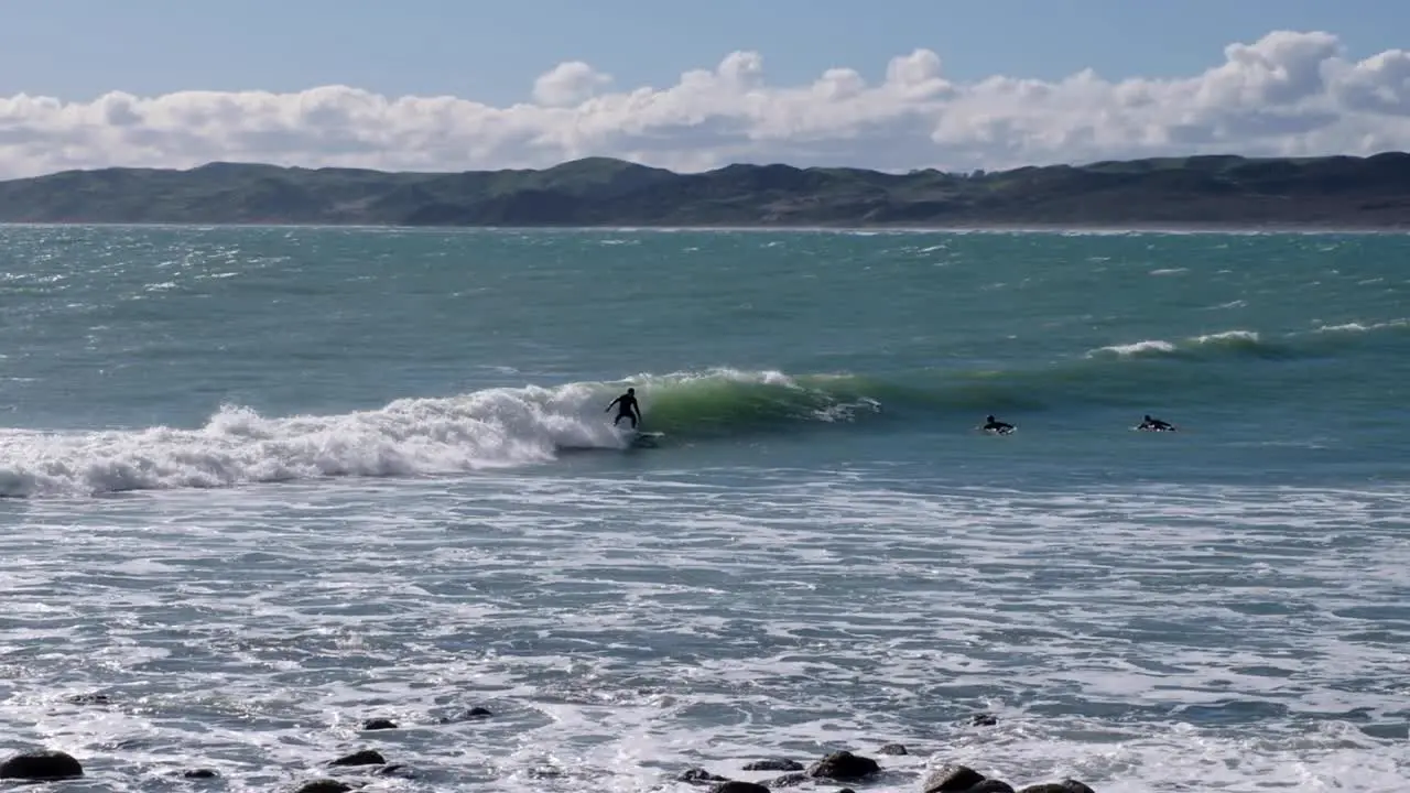 Surfers catching waves in surfing town of Raglan in Waikato New Zealand Aotearoa