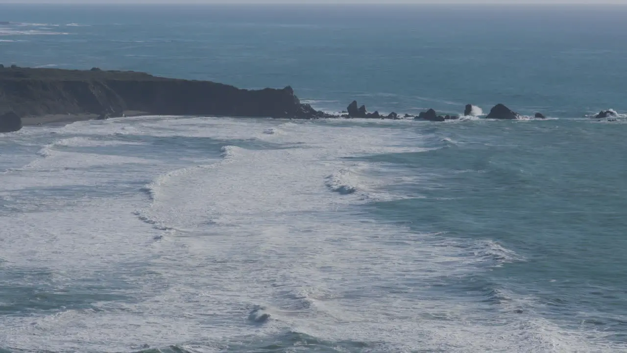 Stationary shot of waves shredding though the waters of the Pacific Ocean located in Big Sur California