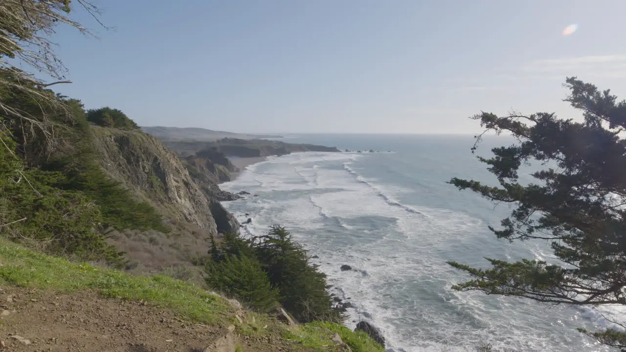 view from mountainside of Big Sur Beach California with waves of the Pacific Ocean rolling in