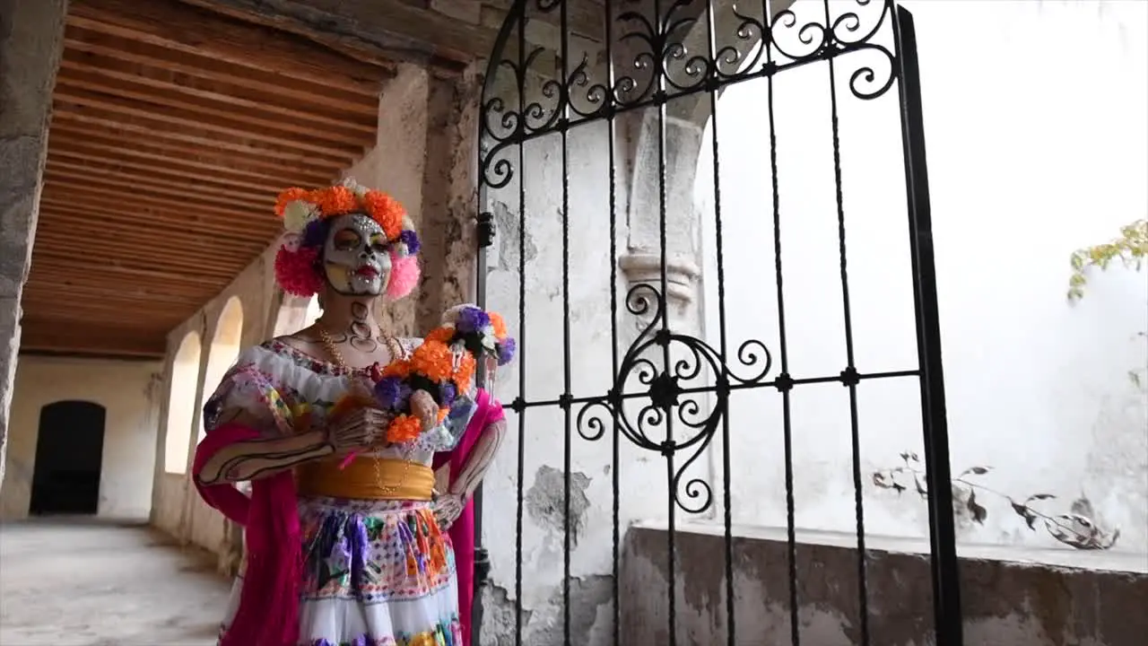 Catrina woman walking in old house with flowers on her head