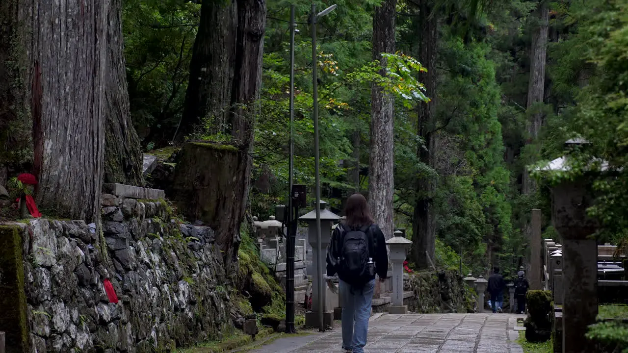 Visitors exploring sacred shrines in Japanese Okunoin cemetery Wakayama