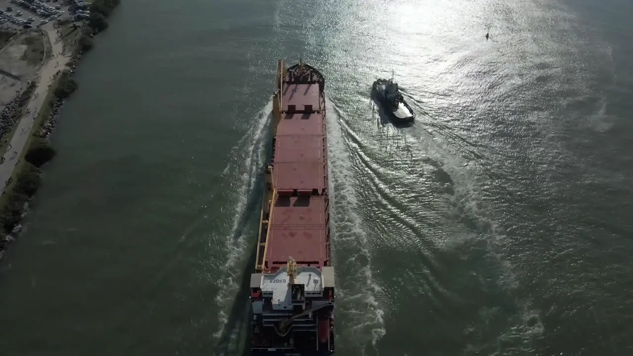 Ship Sailing Into Harbor City Skyline in Background Aerial Tilt Up