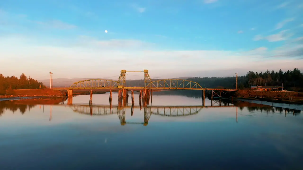 Drone Flying Over Bullards Bridge With Specular Reflection On Coquille River During Sunset Near Bandon Marsh National Wildlife Refuge In Oregon USA