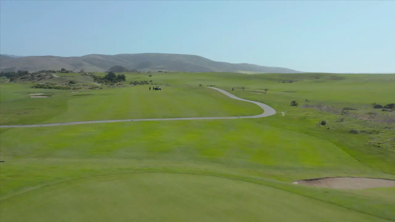 Aerial drone shot of a lawnmower cutting the grass at a gold course in Half Moon Bay California USA