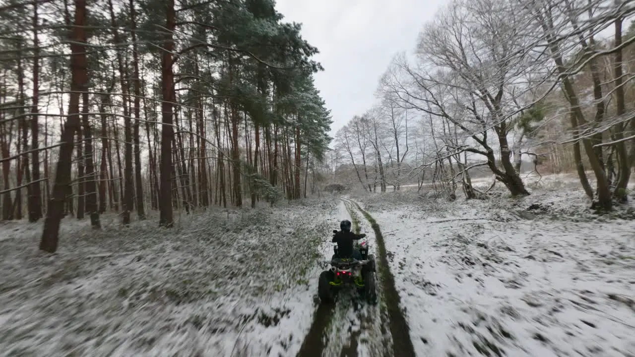 Offroad of atv riders speeding in middle of forest in winter season