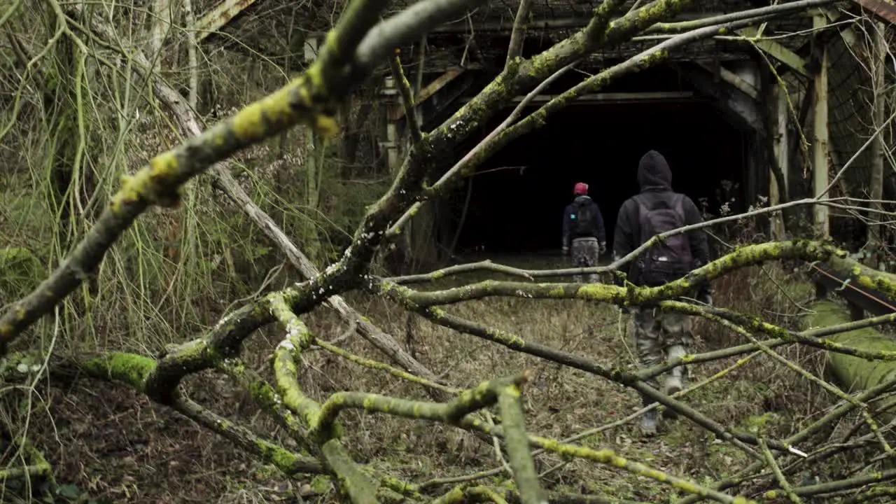 Two young men entering an abandoned tunnel