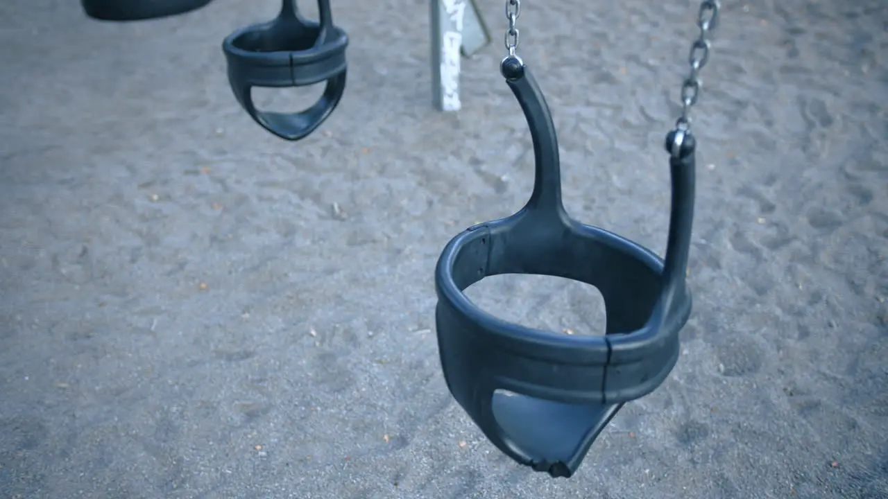 Empty playground swings swinging